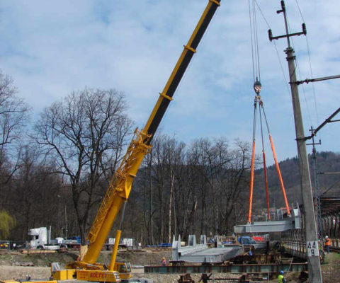 Dźwig ostrożnie przenosi fragment mostu na miejsce docelowe