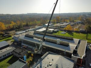 Mikołów - prace montażowe żurawiem Sołtys - montowanie maszyny przez dach hali 11 2022